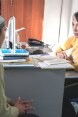 A lawyer sits at her desk and discusses with a woman.