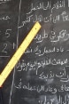 Während eines Kurses in einem Alphabetisierungszentrum in Oum Hadjer, Region Batha, Tschad, liest eine junge Mutter mit einem Lineal in der Hand an der Wandtafel.