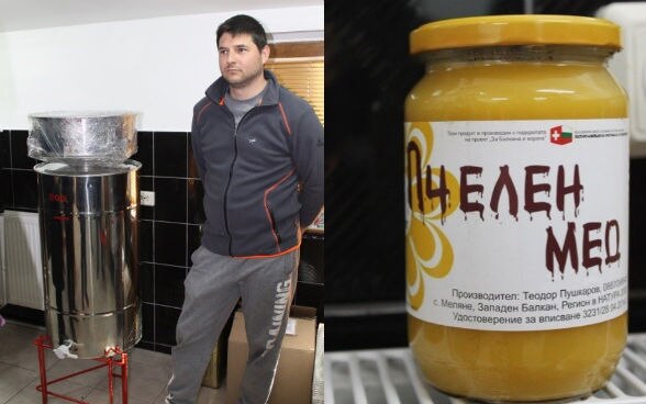 A man standing next to a machine and a jar of honey to his right.