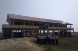 Eine Schulklasse steht vor einer wiederaufgebauten Schule.  