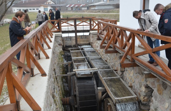 Un gruppo di turisti visita un vecchio mulino ad acqua di duecento anni, totalmente ristrutturato.