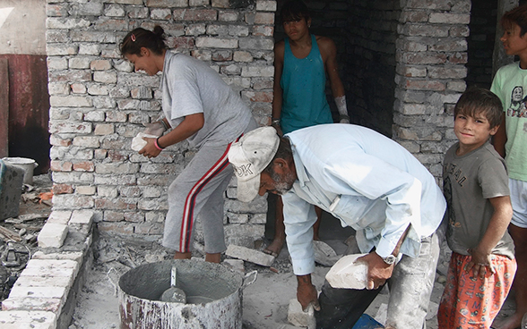 Eine Roma-Familie baut Mauern für ihr Haus.