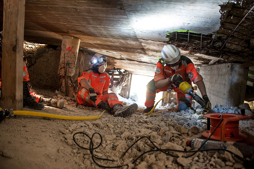 Three rescuers training in rubble. 