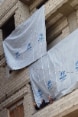 Ein Gebäude mit UNHCR-Fahnen und zwei verschleierten Frauen auf einem Balkon.