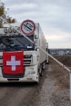 Un soldato alza una sbarra per far passare un camion dell’Aiuto umanitario svizzero.