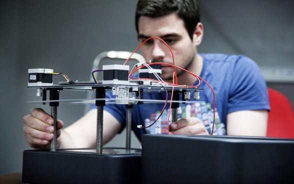 A young man working on an electrical system. 