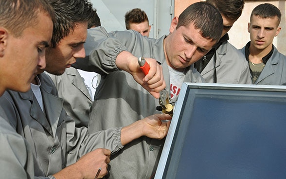 Des apprentis en Albanie travaillent sur une machine thermo-hydraulique.