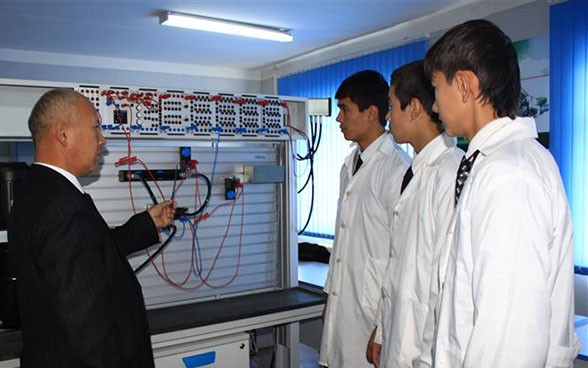 Un insegnante e tre apprendisti davanti a un quadro elettrico