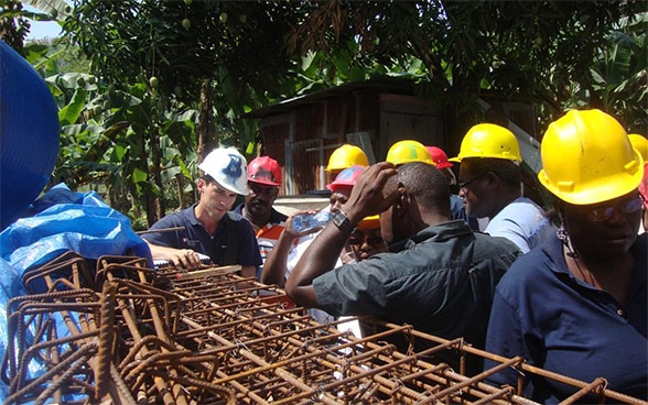 Ein Mitglied des Schweizerischen Korps für Humanitäre Hilfe (SKH) unterhält sich in Haiti mit Auszubildenden.