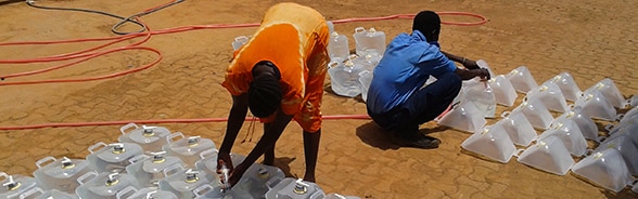 People being provided with water from a tank in South Sudan