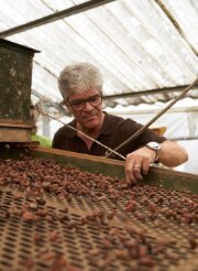 Anton von Weissenfluh devant une bande transporteuse de fèves de cacao