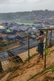Ein Mann steht am Rande des Flüchtlingslagers Cox’ Bazar und baut eine Hütte aus Holz für seine Familie.