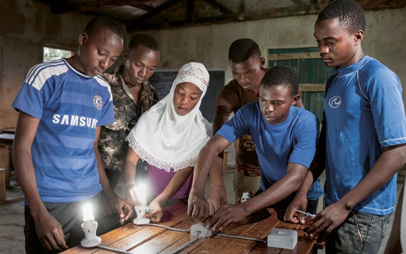 Alcuni giovani, tra cui una ragazza, partecipano a una formazione da elettricisti in un centro di formazione professionale in Tanzania.