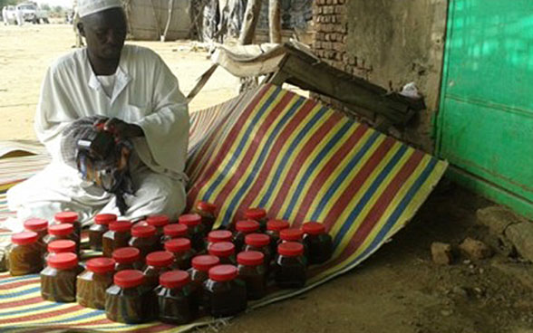 Le Soudanais Abdul-Aziz Mohammed Salih vend son miel au marché de Bindisi, au Darfour. 