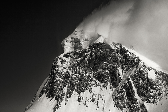 Black-and-white shot of a snow-covered mountain peak.