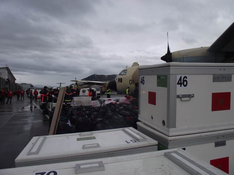 Kisten und Säcke mit Hilfsmaterial vor den drei Militärflugzeugen am Flughafen Bern. 