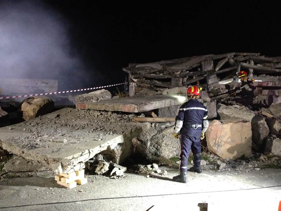 two Moroccan rescue workers in a destroyed building during a night-time training exercise. 