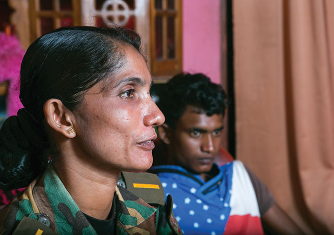 2004 suchte Inoka Priyanjany mit ihrem Sohn Lakhsan in einem Tempel Schutz vor dem Tsunami. Kurz danach wurde bei ihr Krebs im Frühstadium diagnostiziert. Inoka ist in doppelter Hinsicht eine Überlebende. Heute arbeitet sie als Unterkommandantin für eine Einheit der paramilitärischen «Civil Defence Force», die der Polizei angegliedert ist. © R.H. Samarakone/DEZA