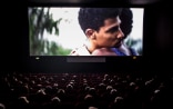 Dans l’obscurité d’une salle de cinéma: sur l’écran, deux hommes se serrent dans les bras.