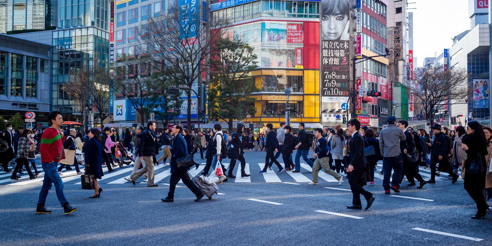 Des personnes en fin de journée traversent un carrefour à Tokyo.