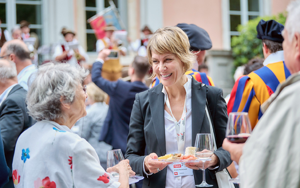 Das Bild zeigt die Eröffnungsapéro in Lugano, mit Direktorin Ariane Rustichelli in der Mitte.