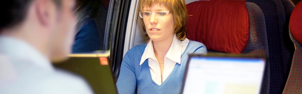 Un homme et une femme travaillant à l'ordinateur dans un train