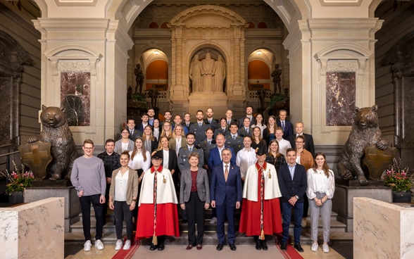 President Ignazio Cassis and Federal Councillor Viola Amherd with about 20 athletes inside the Parliament building.