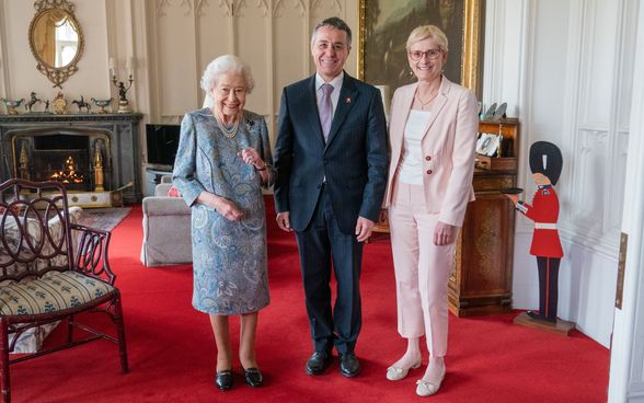 Bundespräsident Cassis steht zwischen seiner Frau Paola Rodoni und Queen Elizabeth II.
