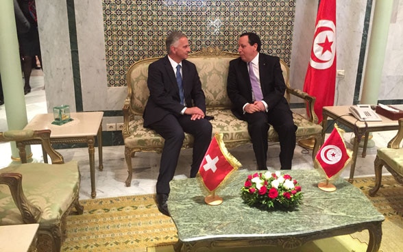 Assis sur un sofa, le conseiller fédéral Didier Burkhalter et le ministre tunisien des affaires étrangères Khemaies Jhinaoui discutent de divers sujets.