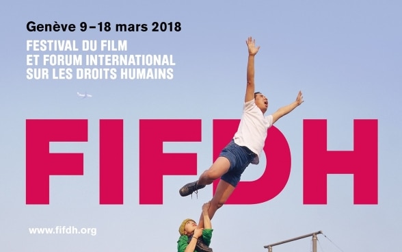 Une femme tient un homme par la jambe pour l’empêcher de s’envoler. À l’arrière-plan, on voit le logo du FIFDH.