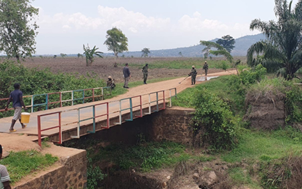 Personnel from the UN mission MINUSCA search for mines near a bridge with mine detectors.