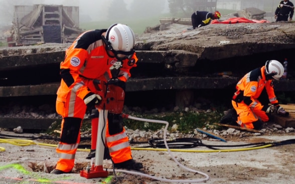 Four members of Swiss Rescue on a exercise mission following an earthquake in a constructed scenario in Epeisses.