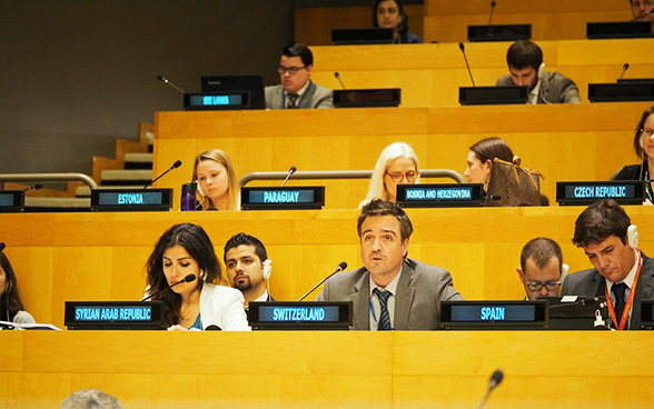 Seated next to representatives of Syria, Cyril Prissette speaks at the United Nations headquarters in New York