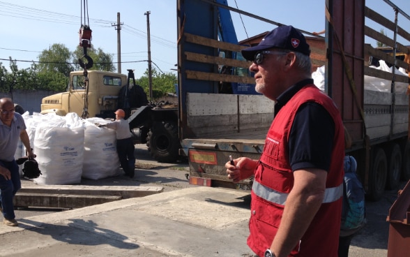 Personnes autour d’un poids lourd stationné devant la succursale des usines hydrauliques de l’organisation de services publics Voda Donbassa à Krasnoarmeïsk.