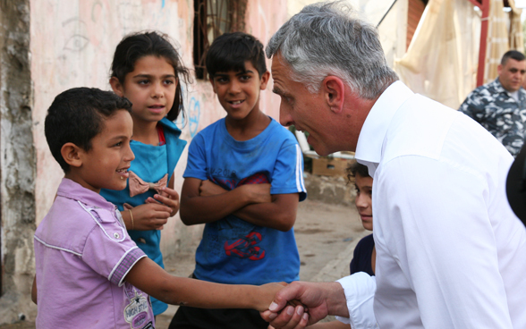 Bundesrat Didier Burkhalter begrüsst Kinder im Quartier in Hay Al-Gharbeh, einem benachteiligten Viertel im Süden der libanesischen Hauptstadt. © EDA