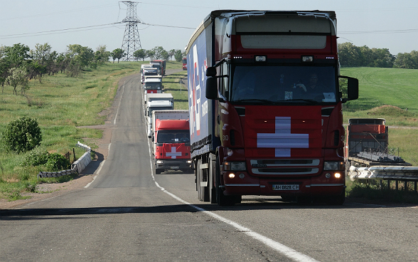 Les camions du convoi humanitaire se suivent sur la route.