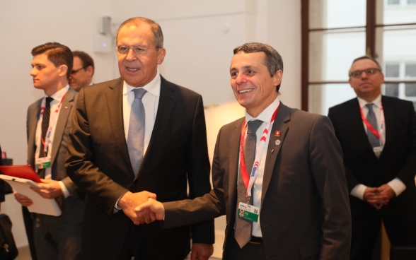 Le conseiller fédéral sert la main à Sergei Lavrov, ministre ukrainien des affaires étrangères.