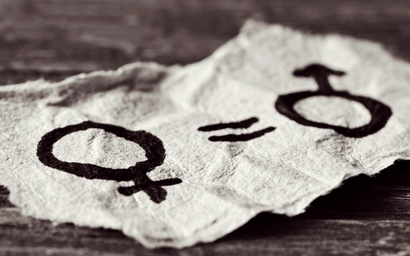 Auf einem Stück Papier stehen die Symbole für Mann und Frau als Zeichen der Gleichstellung der Geschlechter.