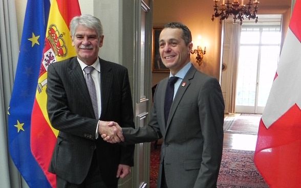 Federal Councillor Ignazio Cassis shakes Alfonso Dastis' hand.