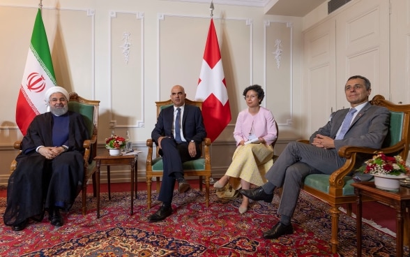 Von links nach rechts. Der iranische Präsident Rohani, Bundespräsident Berset und Bundesrat Ignazio Cassis sitzen in während ihres offiziellen Treffens. Im Hintergrund sind die Fahnen der Schweiz und des Irans zu sehen.