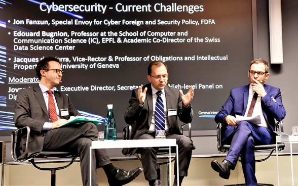 Les participants à la discussion sur la cybersécurité échangent assis sur le podium.