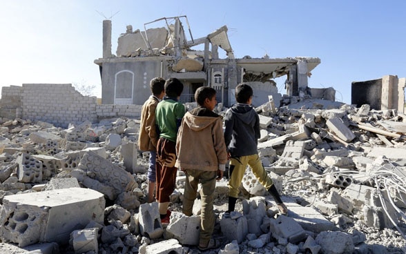 I bambini yemeniti ispezionano un edificio a Sanaâ colpito da incursioni aeree.