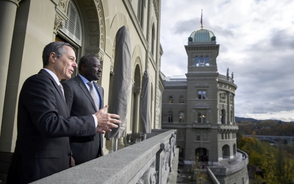 Bundesrat Ignazio Cassis und CTBTO-Exekutivsekretär Lassina Zerbo unterhalten sich auf einem Balkon des Bundeshauses über Atomwaffen.