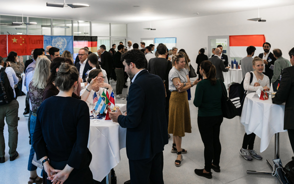 Ambassadors and members of the public discuss around small high tables