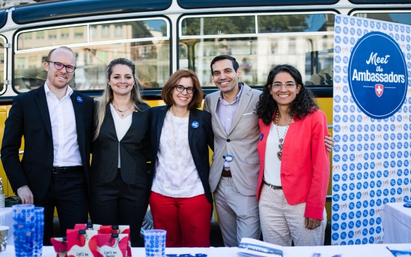 Eine Gruppe von fünf Botschafterinnen und Botschafter posiert vor dem gelben Bus für das Foto