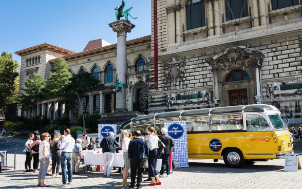 Blick auf den Bus, die Diplomaten und das Publikum vor der Riponne in Lausanne