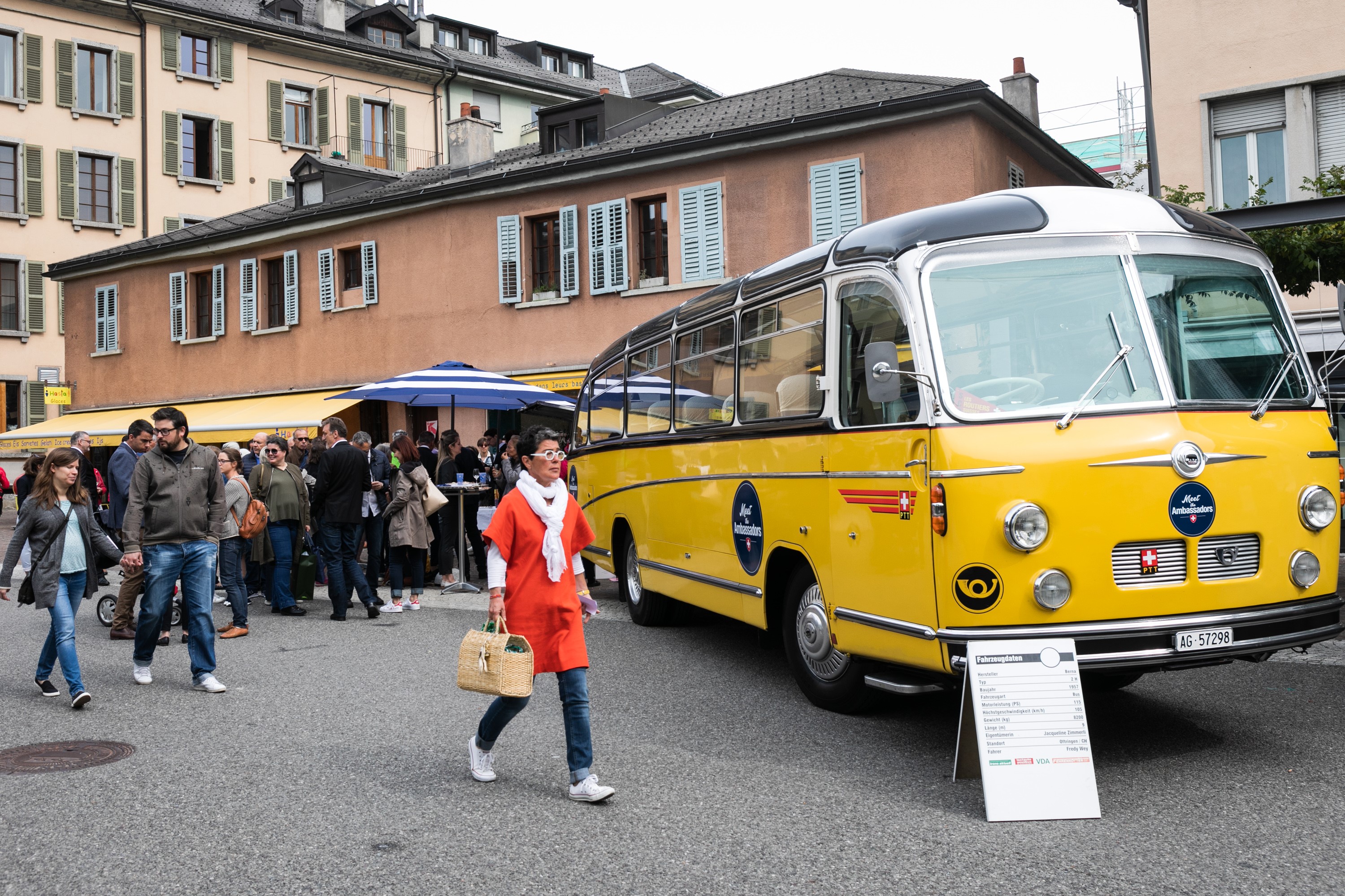 Population of Sion meeting the ambassadors; in the foreground the postal bus Meet the Ambassador