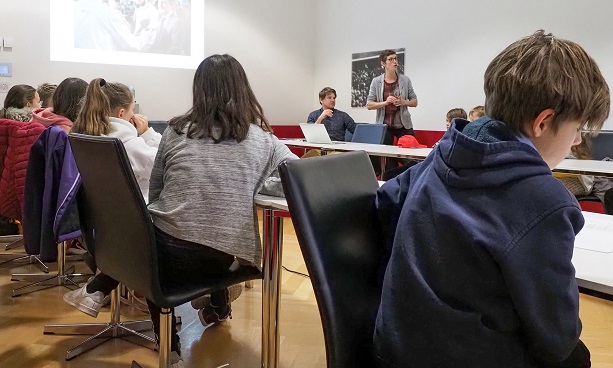 I bambini ascoltano una donna che presenta il lavoro del dipartimento della comunicazione del DFAE.