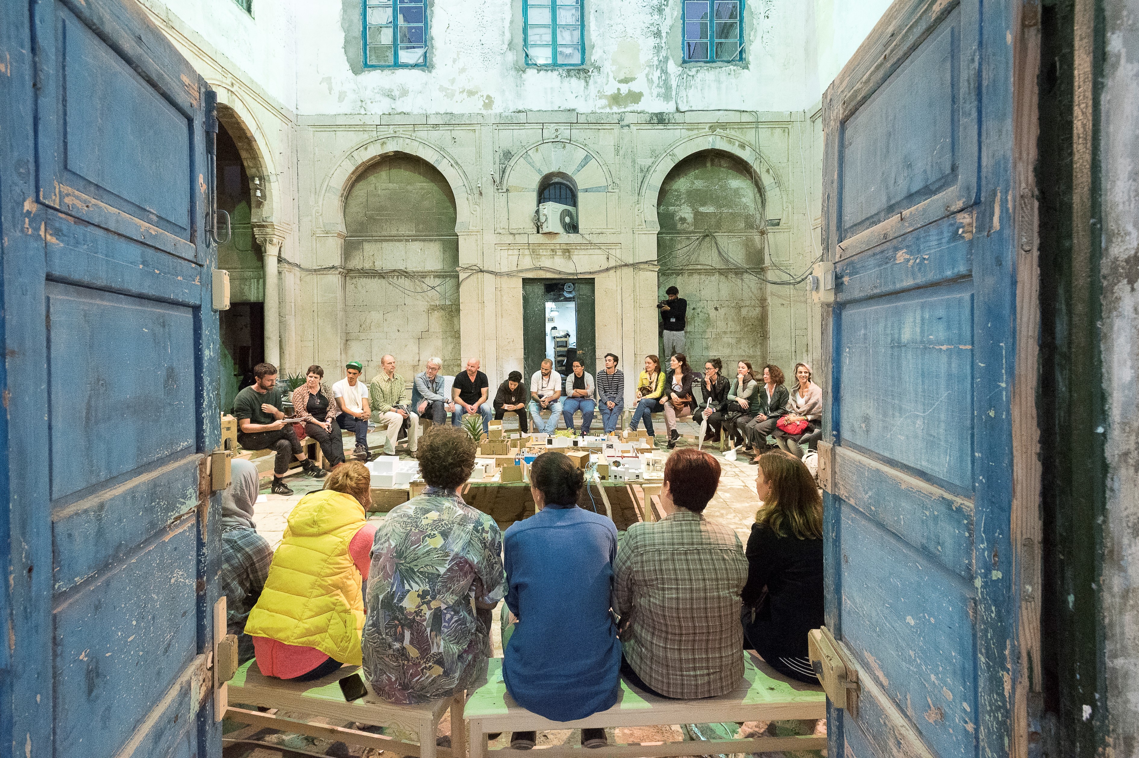 Un gruppo di giovani siede in cerchio nel cortile interno di un edificio in occasione del festival Dream City di Tunisi. 