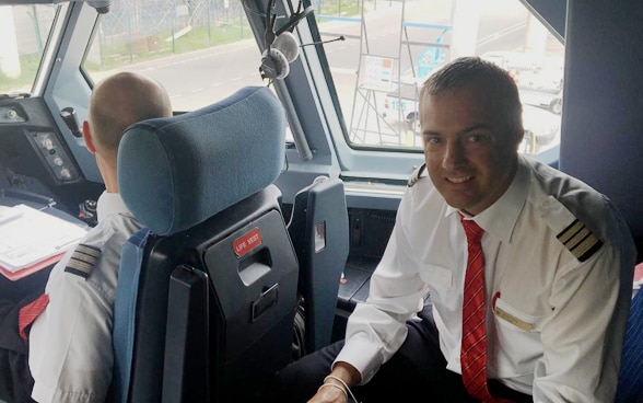 Members of the flight crew are seated in the cockpit of the aircraft that will soon depart for Switzerland. 